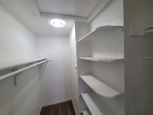 a view of walk in closet with empty racks