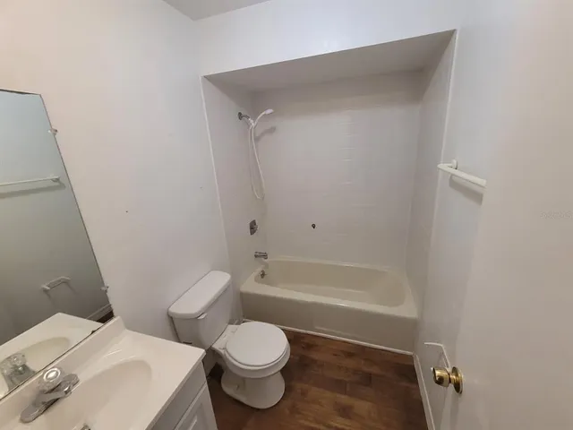 a white toilet sitting next to a bath tub