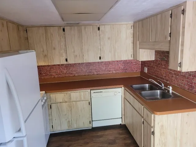 a kitchen with a sink a refrigerator and cabinets