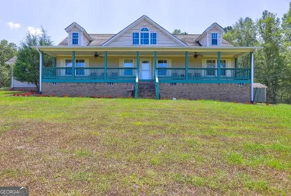a view of house with a garden and a yard