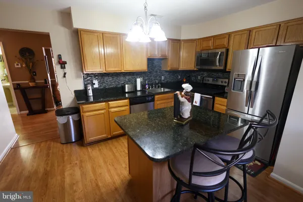 a kitchen with a table chairs refrigerator and microwave