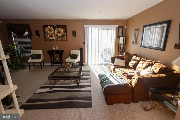 a living room with furniture ceiling fan and a window