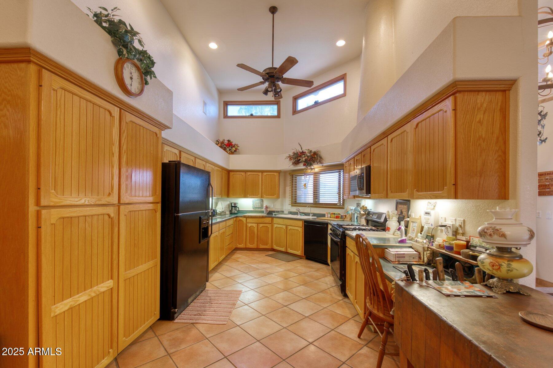 1426 South Foudy Road Bisbee, AZ 85603 - Photo 12 of 60 a kitchen with stainless steel appliances kitchen island granite countertop a refrigerator a sink dishwasher a stove and a dining table with wooden cabinet