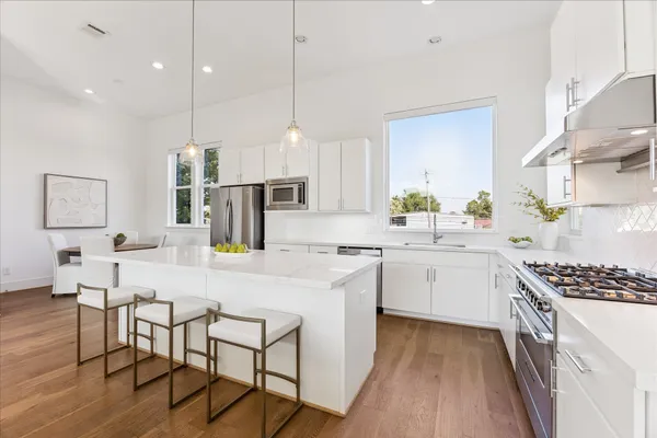 a kitchen with a sink a counter top space stainless steel appliances and cabinets