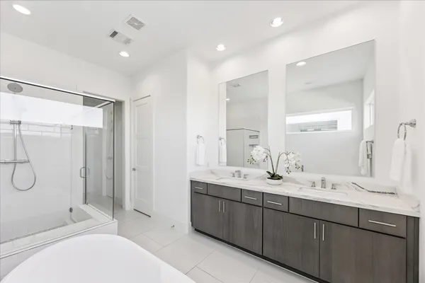 a bathroom with a double vanity sink toilet mirror and shower
