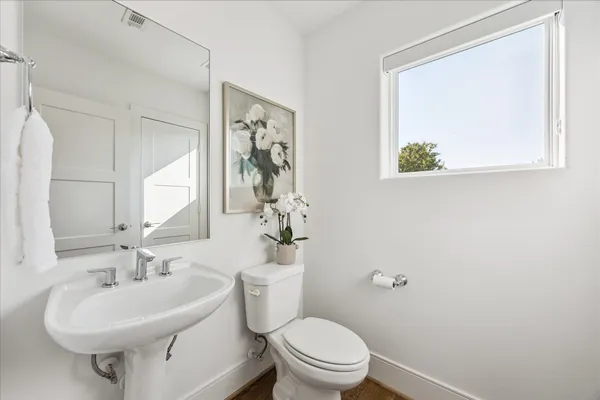 a bathroom with a sink mirror and toilet
