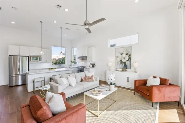 a living room with furniture and a view of kitchen