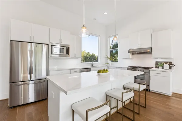 a kitchen with refrigerator cabinets and wooden floor