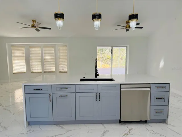 a view of a kitchen with stainless steel appliances granite countertop a refrigerator a sink and a stove