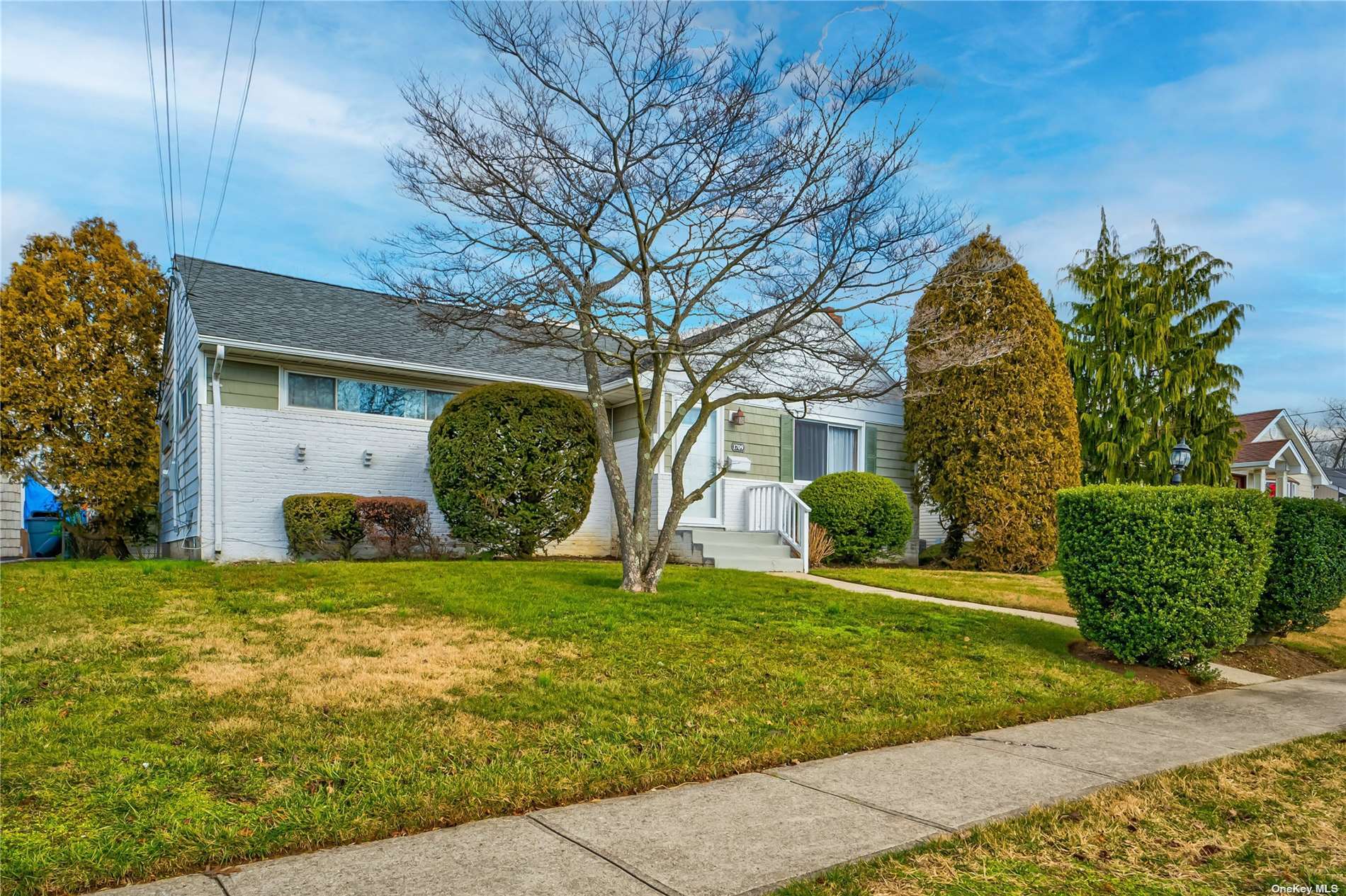 a view of a house with a big yard and large trees