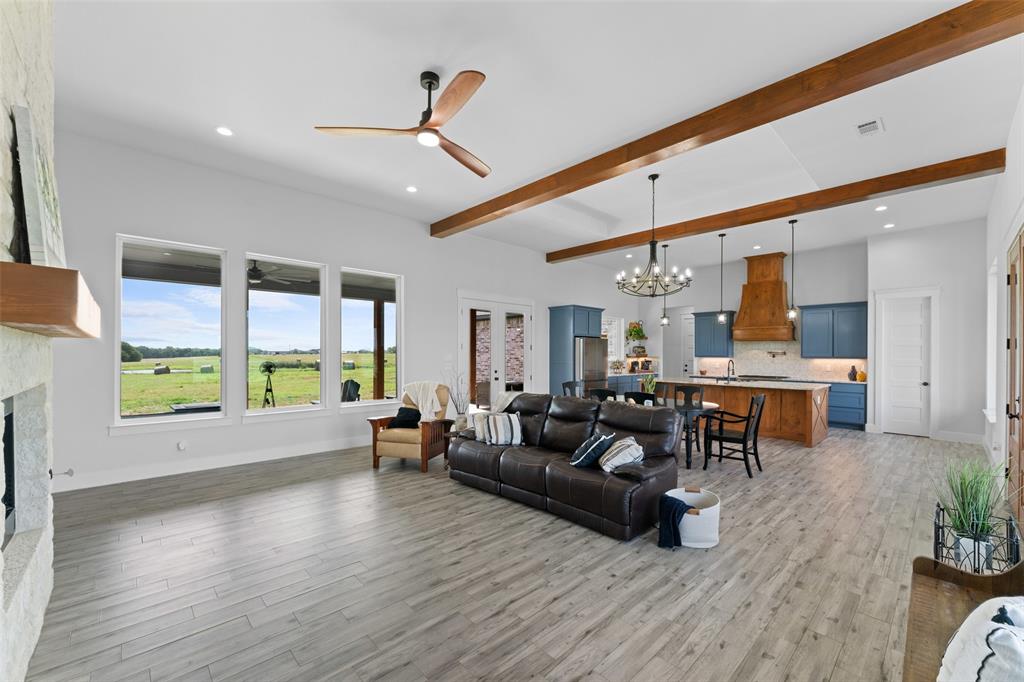 4411 Fm 751 Wills Point Wills Point, TX 75169 - Photo 9 of 40 Spacious living area featuring wood-finish flooring, exposed ceiling beams, and a stone-clad fireplace