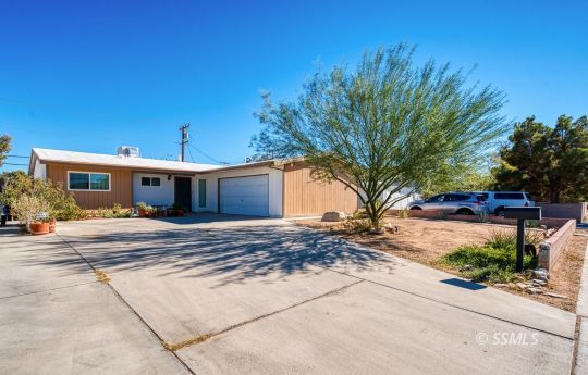 314 Lenore Street Ridgecrest, CA 93555 - Photo 2 of 29 a front view of a house with a yard and a garage