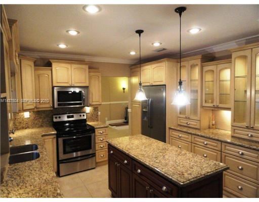 9261 Southwest 88th Terrace Miami, FL 33173 - Photo 4 of 16 a kitchen with stainless steel appliances kitchen island granite countertop a stove and refrigerator