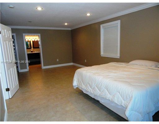 9261 Southwest 88th Terrace Miami, FL 33173 - Photo 7 of 16 a spacious bedroom with a bed and a television