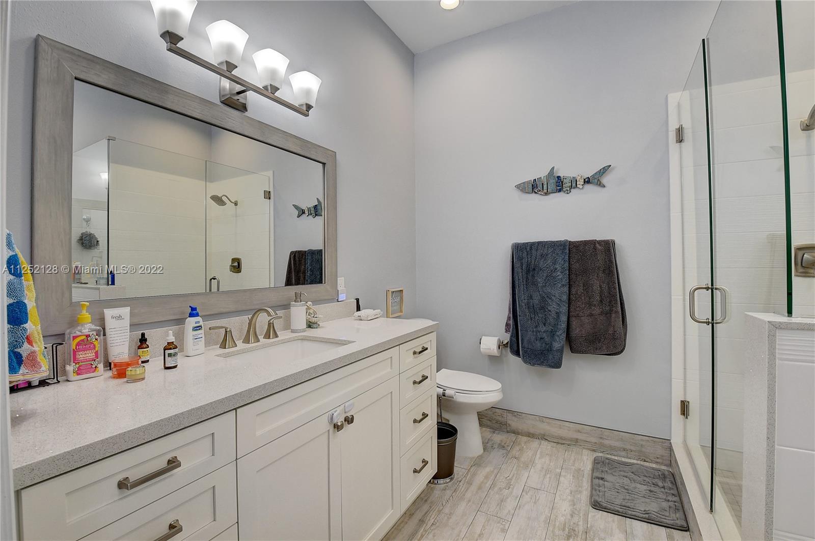 Boca Gardens Boca Raton, FL 33496 - Photo 7 of 19 a bathroom with a sink a toilet and mirror