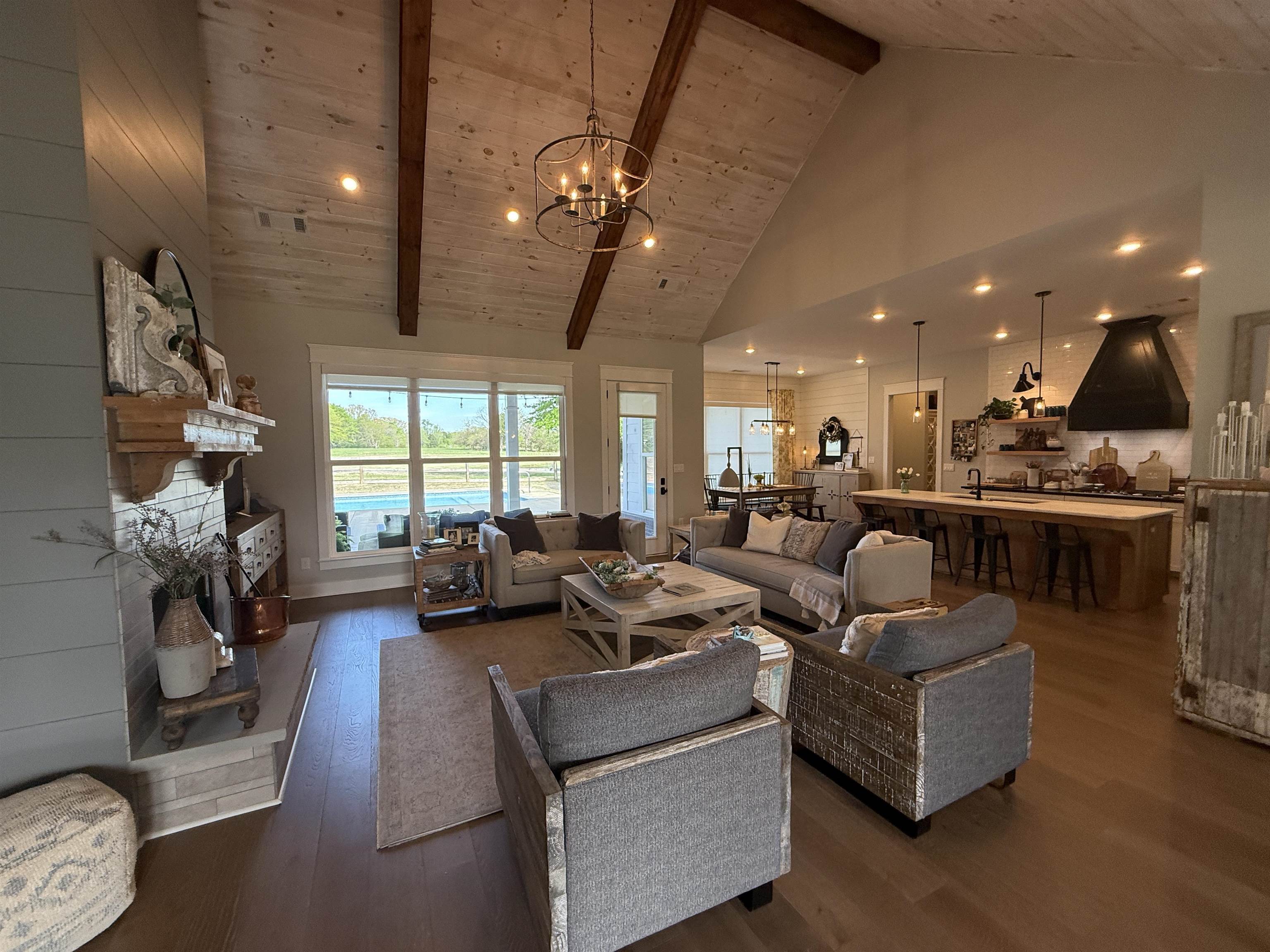 6900 Salem Road Lakeland, TN 38002 - Photo 11 of 40 Living room featuring suspended lighting, dark wood finished floors, a fireplace with raised hearth, and a high wood beamed ceiling