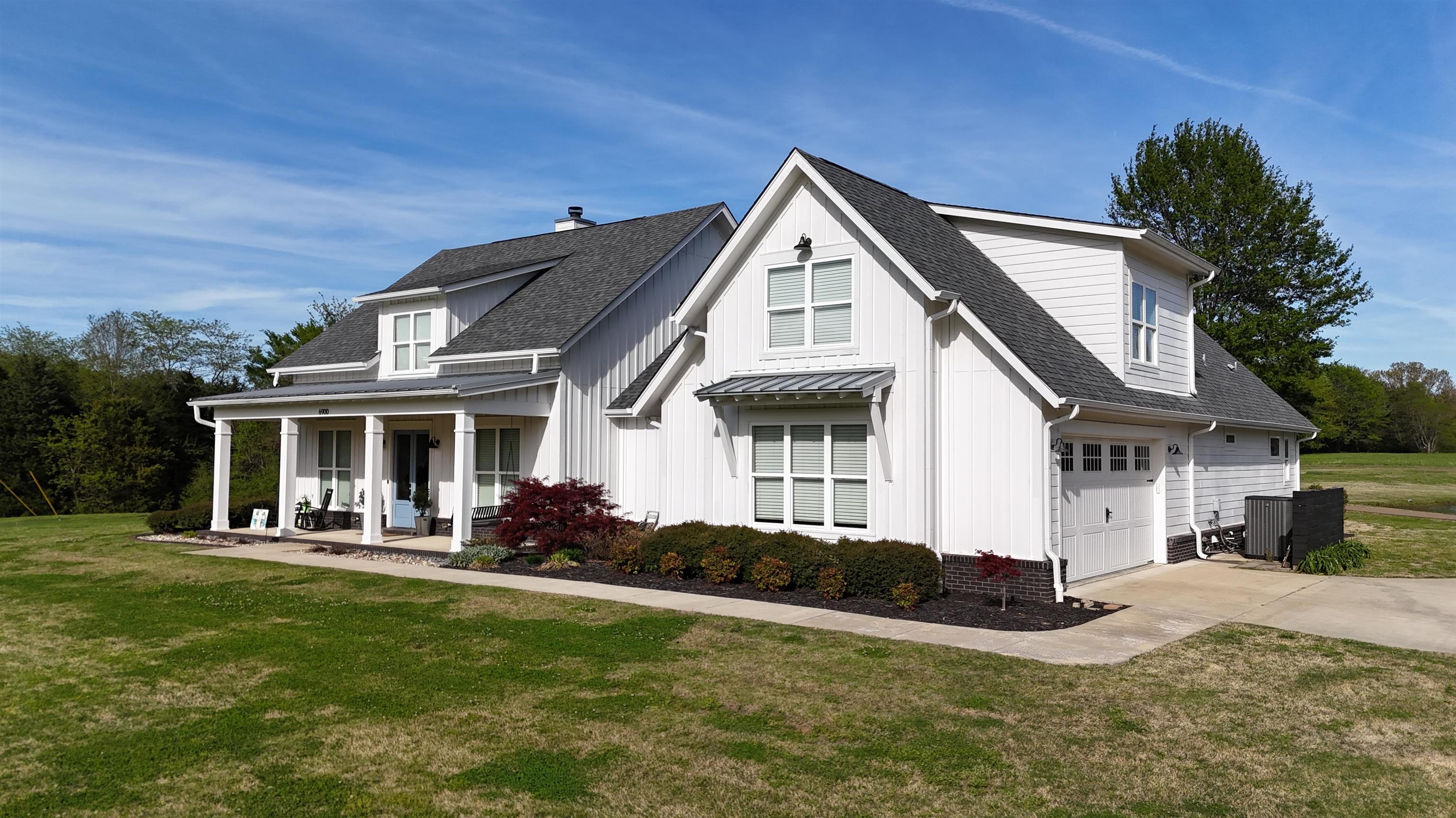 6900 Salem Road Lakeland, TN 38002 - Photo 2 of 40 Modern inspired farmhouse with a front yard, a shingled roof, covered porch, driveway, and board and batten siding
