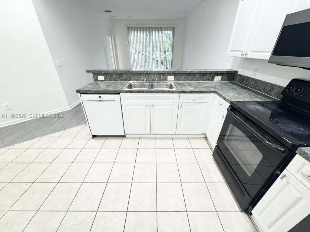 a kitchen with a sink cabinets and a stove top oven