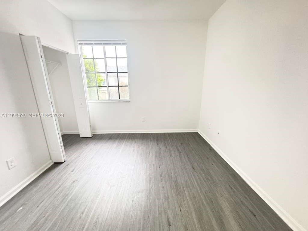 1953 Freeport Drive, Unit 1953 Riviera Beach, FL 33404 - Photo 11 of 30 an empty room with wooden floor and windows