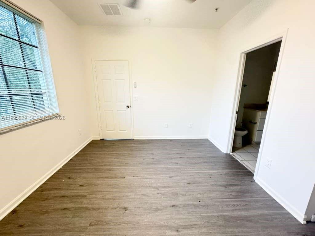 1953 Freeport Drive, Unit 1953 Riviera Beach, FL 33404 - Photo 12 of 30 an empty room with wooden floor and windows