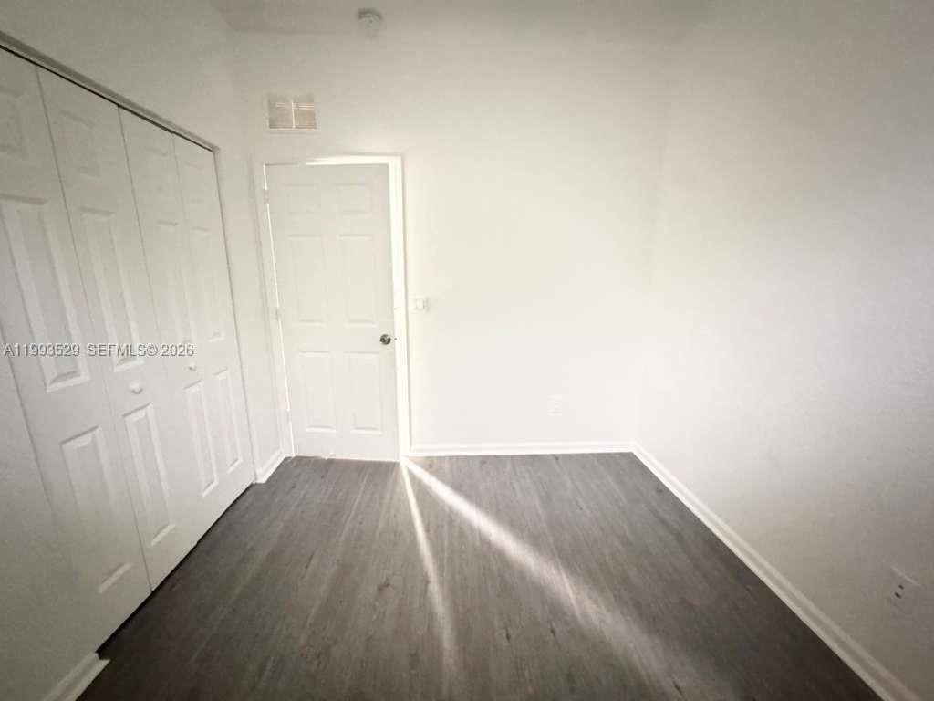 1953 Freeport Drive, Unit 1953 Riviera Beach, FL 33404 - Photo 14 of 30 a view of an empty room with wooden floor