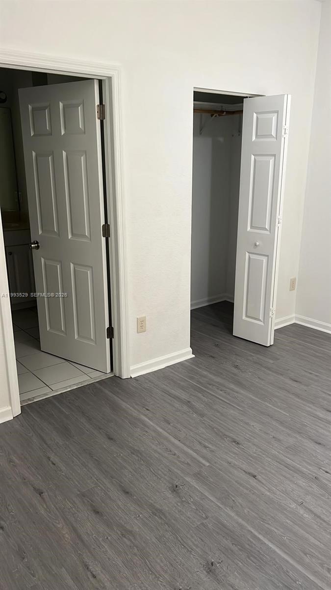 1953 Freeport Drive, Unit 1953 Riviera Beach, FL 33404 - Photo 16 of 30 an empty room with wooden floor and a hallway