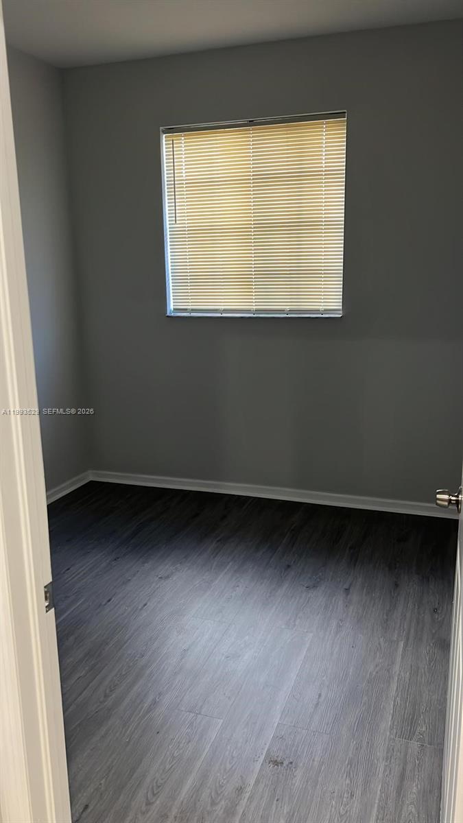 1953 Freeport Drive, Unit 1953 Riviera Beach, FL 33404 - Photo 19 of 30 an empty room with wooden floor and windows