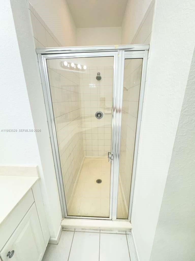 1953 Freeport Drive, Unit 1953 Riviera Beach, FL 33404 - Photo 26 of 30 a bathroom with a glass shower door