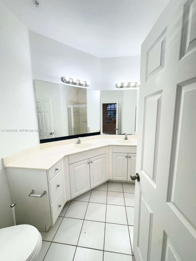 1953 Freeport Drive, Unit 1953 Riviera Beach, FL 33404 - Photo 27 of 30 a bathroom with a sink a toilet and mirror