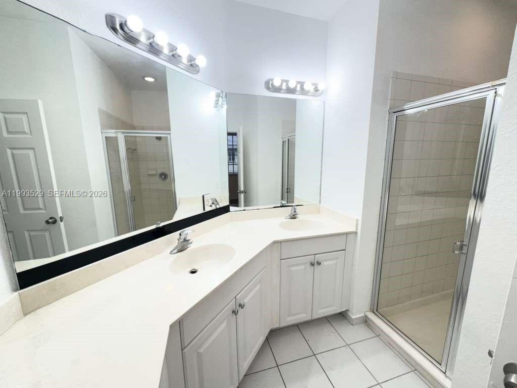 1953 Freeport Drive, Unit 1953 Riviera Beach, FL 33404 - Photo 28 of 30 a bathroom with a double vanity sink mirror and shower