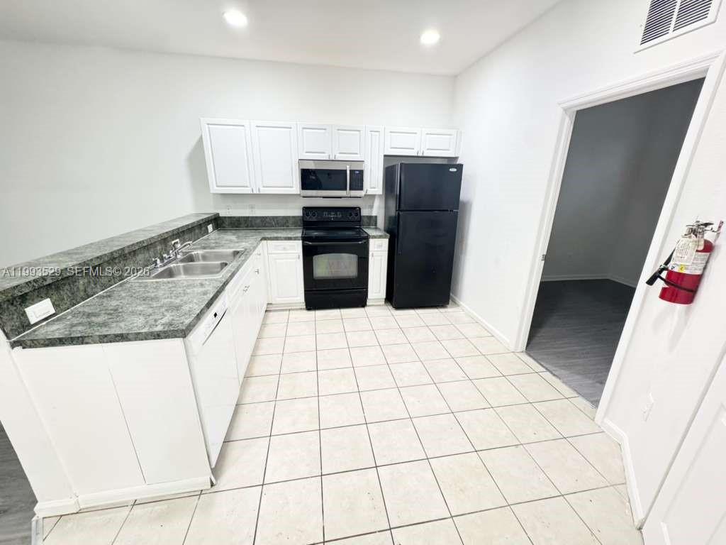 1953 Freeport Drive, Unit 1953 Riviera Beach, FL 33404 - Photo 4 of 30 a kitchen with granite countertop a refrigerator and a stove top oven