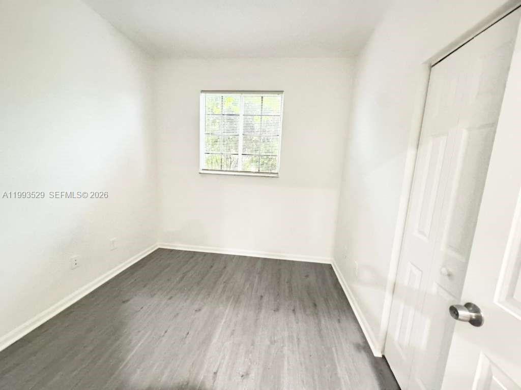 1953 Freeport Drive, Unit 1953 Riviera Beach, FL 33404 - Photo 8 of 30 an empty room with wooden floor and windows