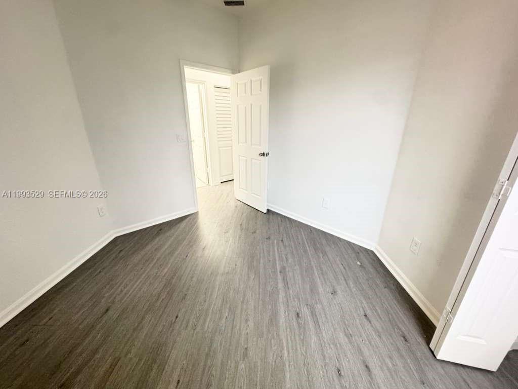 1953 Freeport Drive, Unit 1953 Riviera Beach, FL 33404 - Photo 9 of 30 an empty room with wooden floor