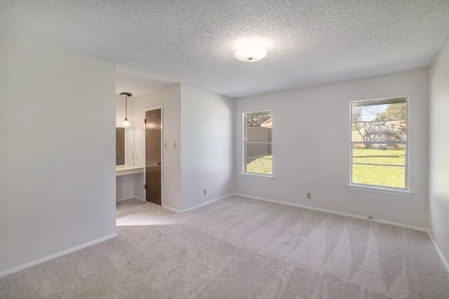 an empty room with windows and closet
