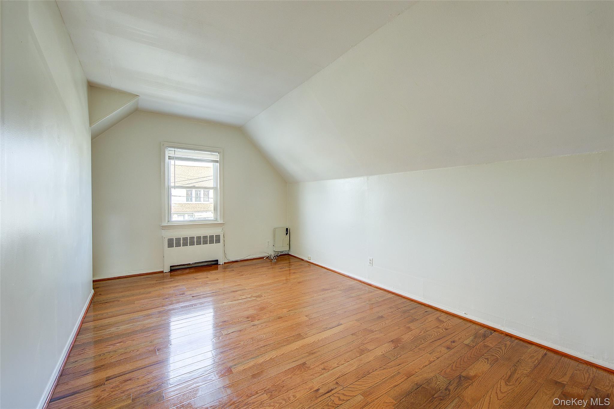 220-04 103rd Avenue Queens, NY 11429 - Photo 18 of 35 an empty room with wooden floor and windows