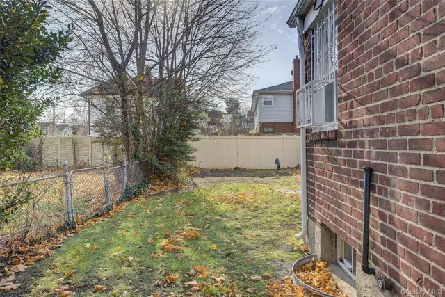 a view of a house with a yard and wooden fence