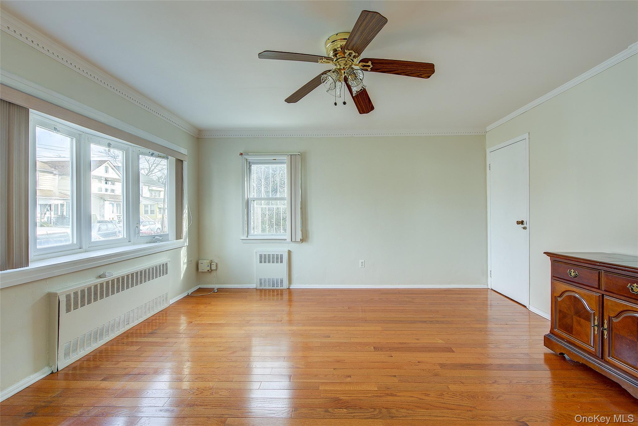 220-04 103rd Avenue Queens, NY 11429 - Photo 5 of 35 a view of an empty room with a window and wooden floor