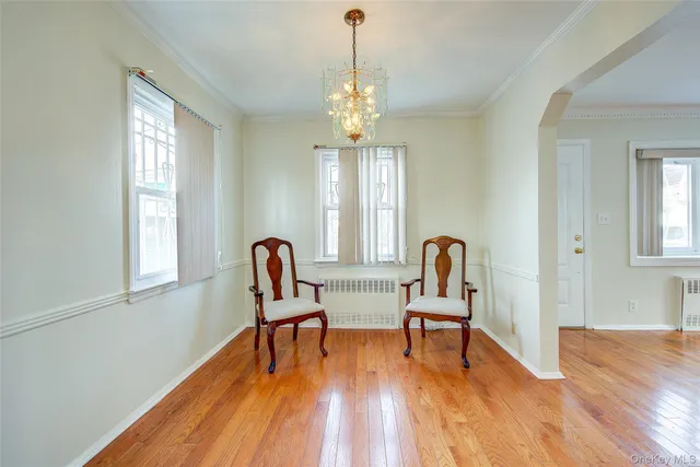 a view of a a dining room with furniture window and wooden floor