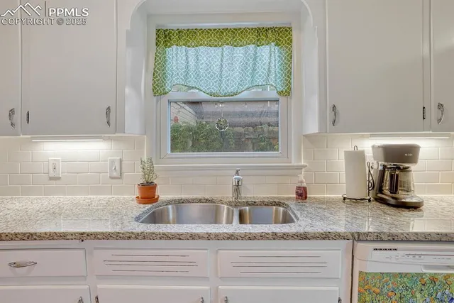 a kitchen with granite countertop a sink and a window