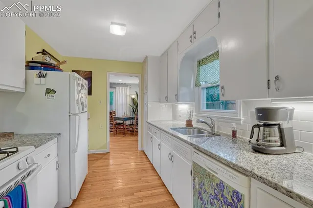 a kitchen with granite countertop a sink stove and refrigerator