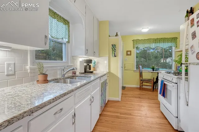 a kitchen with stainless steel appliances granite countertop a sink and a wooden floors