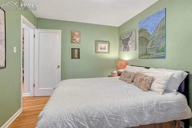 a bedroom with a bed and a painting on the wall