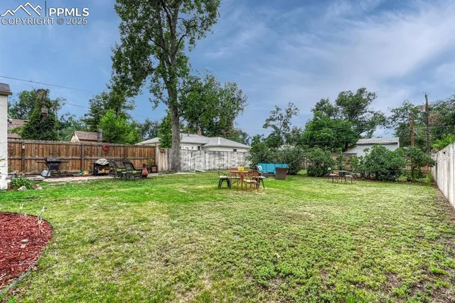a backyard of a house with table and chairs