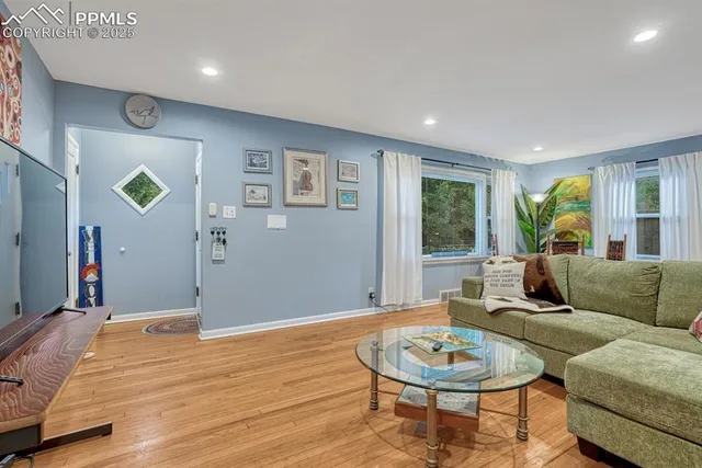 a living room with furniture and a wooden floor
