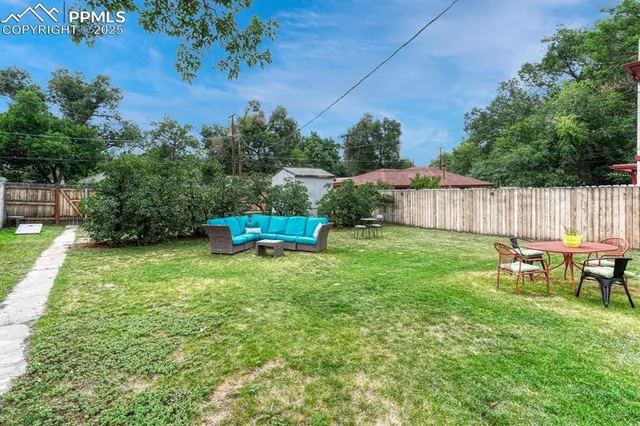 a backyard of a house with table and chairs