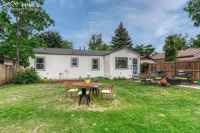 a backyard of a house with table and chairs