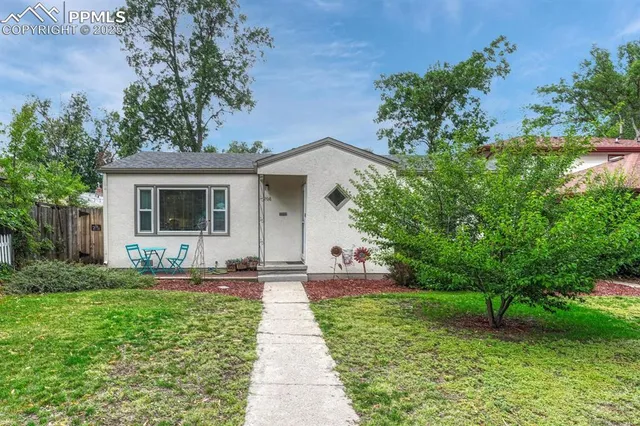 a front view of a house with a yard and trees