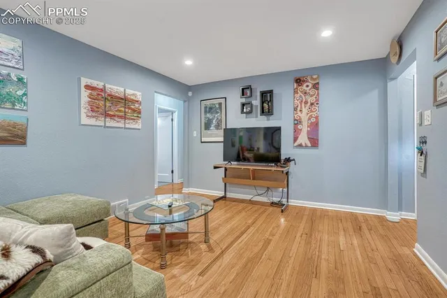 a living room with furniture and a wooden floor