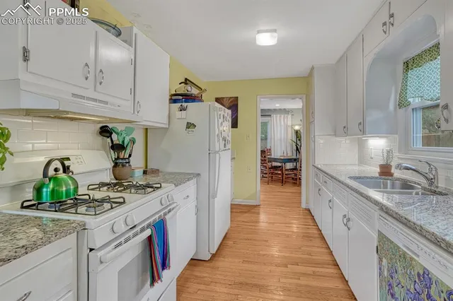 a kitchen with kitchen island granite countertop a sink stove and refrigerator