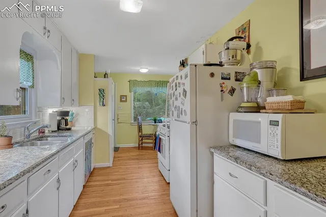 a spacious bathroom with a granite countertop double vanity sink a mirror and a shower